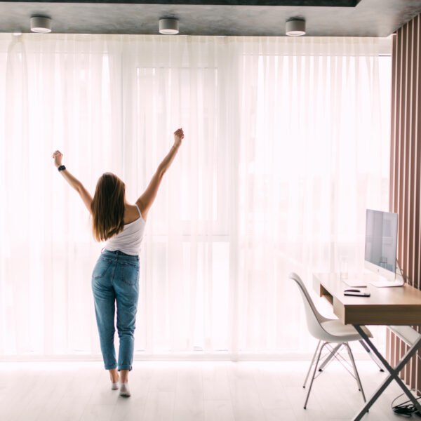 Young woman stretching at home in front of window in the morning